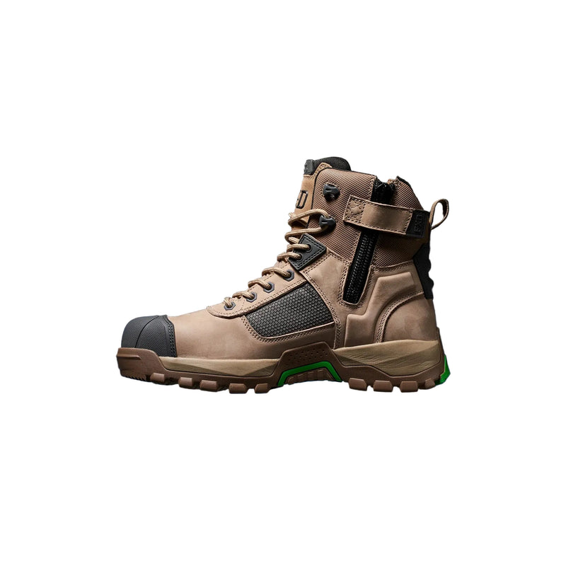 A single mid-cut tactical boot in tan and brown with black mesh panels, a black heel cap, and a small green accent near the sole, shown in profile against a black background with a blue glow beneath the boot.