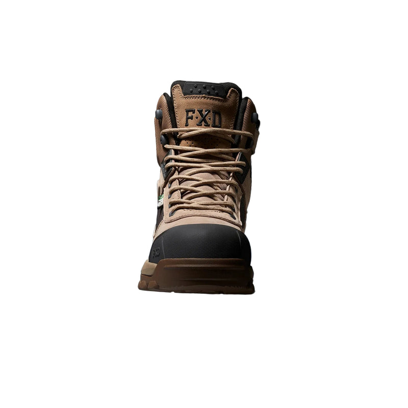 A single FXD mid-top work boot in tan and black, shown from the front against a dark background with a blue glow at the base.