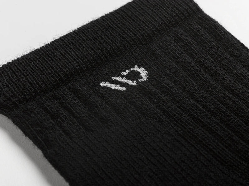 Black sock with a logo on a light gray background
