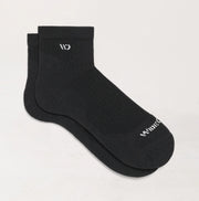 Two black socks with a brand logo on a light gray background