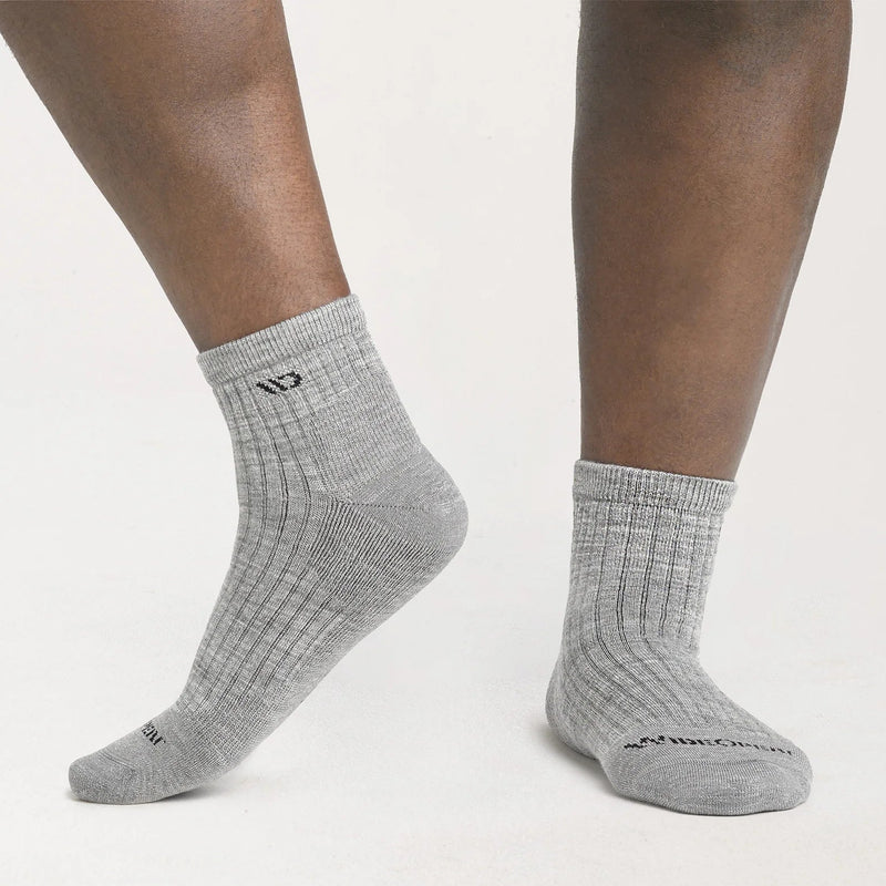 Gray socks worn by a person on a light gray background
