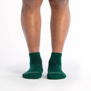 Green socks worn by a person on a white background