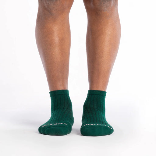 Green socks worn by a person on a white background