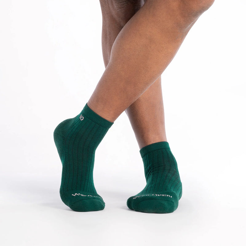 Green socks worn by a person on a white background