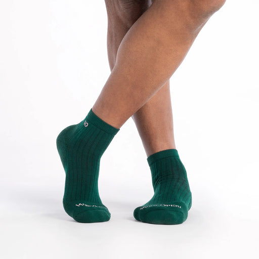 Green socks worn by a person on a white background