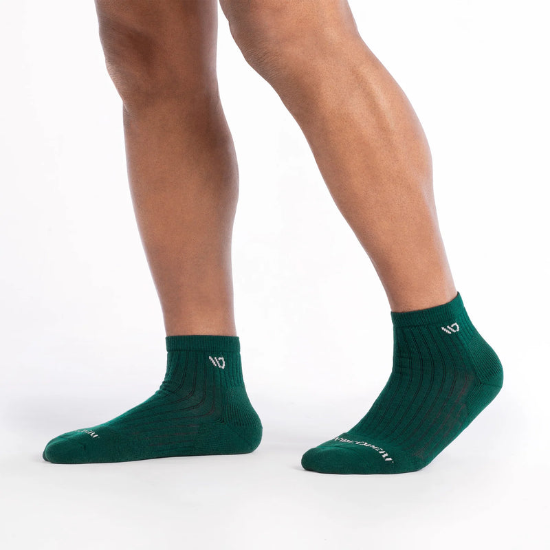 Green socks worn by a person on a white background
