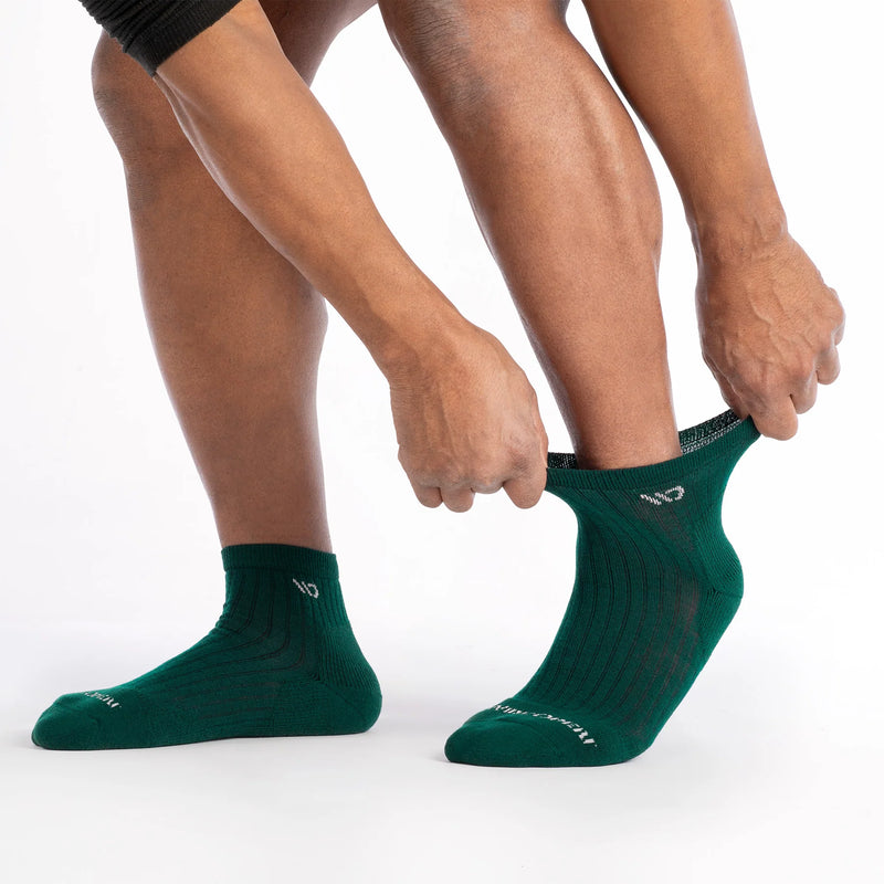 Person wearing green socks on a white background