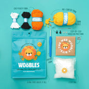 Woobles learn to crochet kit with yarn, hook, and packaging on a teal background
