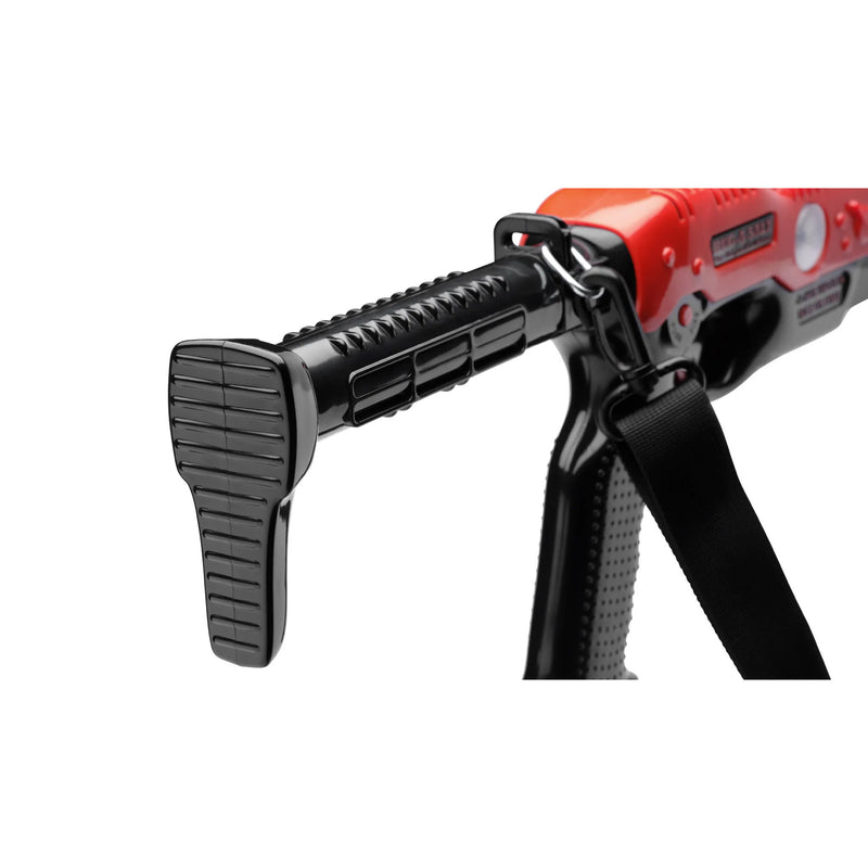 Close-up of a red and black toy blaster or prop gun with a black strap attached, shown on a plain white background.