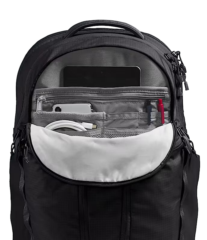 Black backpack unzipped revealing inner pockets and storage compartments against a white background. 