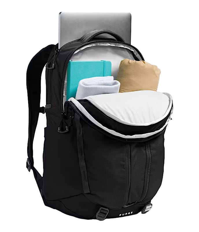 Black backpack unzipped showing various everyday items fitting into it's compartments against a white background. 