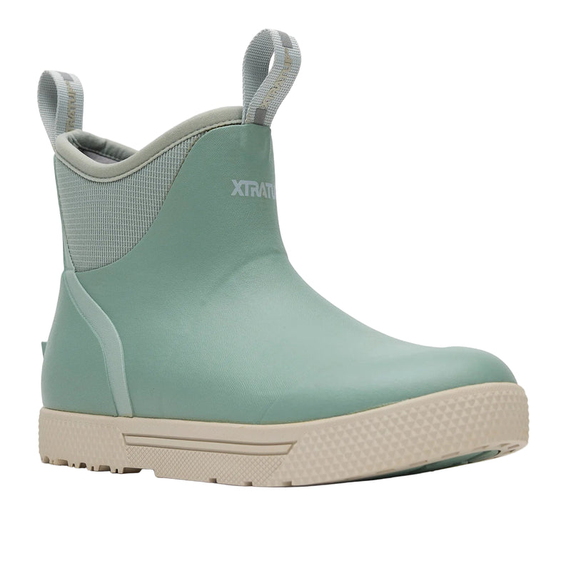 Green rain boot with beige sole on a white background
