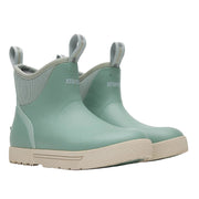 Pair of green rubber boots with beige soles on a white background