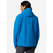 A man wearing a bright blue hooded jacket, shown from the back against a light gray studio background.