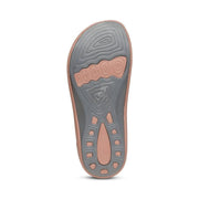Bottom view of the tread of a grey and pink colored sandal against a white background. 