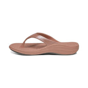 Side view of a pink colored sandal with a visible grey bottom against a white background. 
