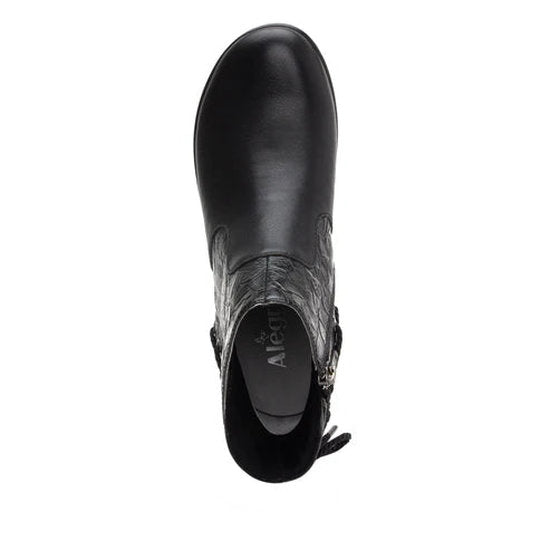 Top-down view of a black ankle boot against a white background. 