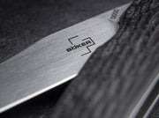 Close up image of the blade and handle of a knife with a visible Boker logo on it.