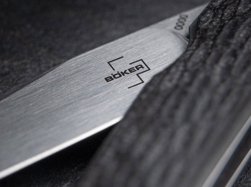 Close up image of the blade and handle of a knife with a visible Boker logo on it.