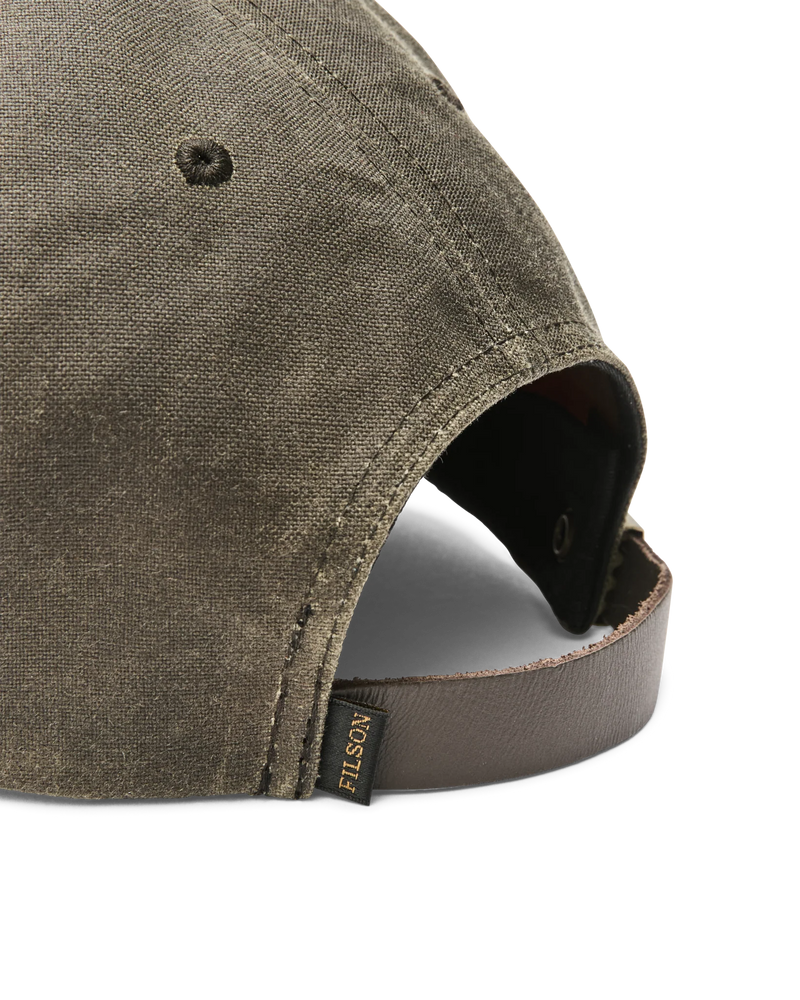 Close up back view of a dark green baseball cap featuring a Filson logo against a white background.