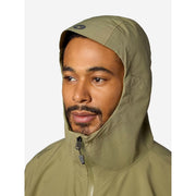 A close-up of a man wearing an olive green hooded jacket, showing the hood up and a zipper at the neck, against a light gray background.