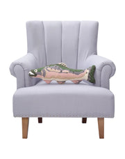 Pink, gray, and green fish shaped throw pillow sitting on a chair against a white background. 