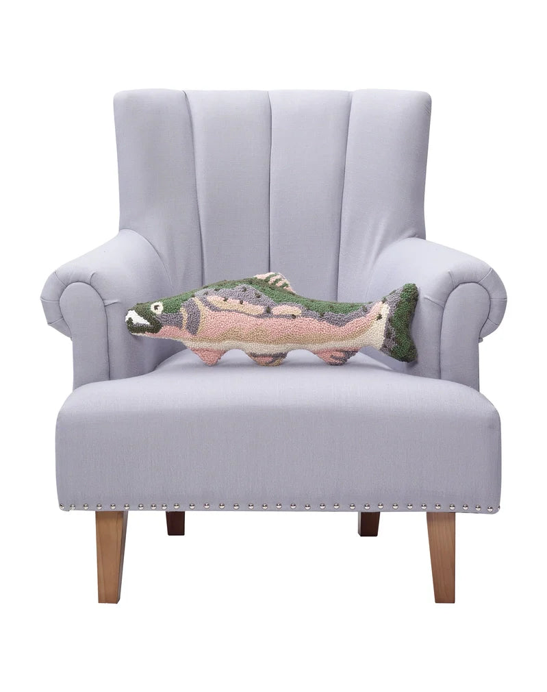 Pink, gray, and green fish shaped throw pillow sitting on a chair against a white background. 