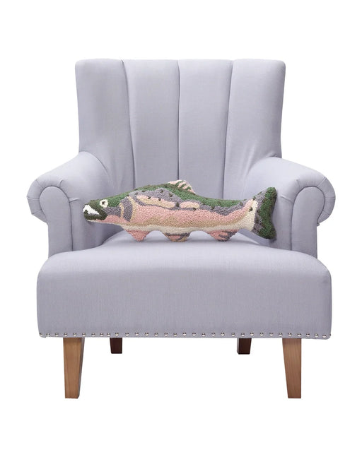 Pink, gray, and green fish shaped throw pillow sitting on a chair against a white background. 
