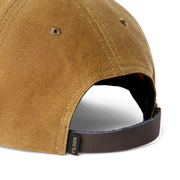Close up back view of a brown baseball cap featuring a Filson logo against a white background. 