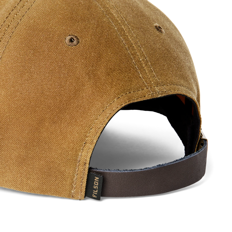 Close up back view of a brown baseball cap featuring a Filson logo against a white background. 