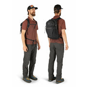 Man wearing a black backpack on a white background.