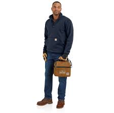 Man wearing a navy 1/4 zip jacket with a Carhartt logo on the pocket on a white background.