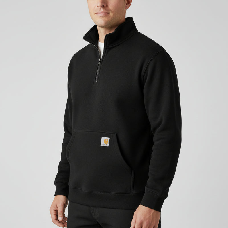 Man wearing a black 1/4 zip jacket with a Carhartt logo on the pocket on a white background.