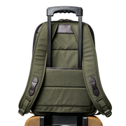 Back view of an olive colored backpack featuring a carrying handle against a white background. 