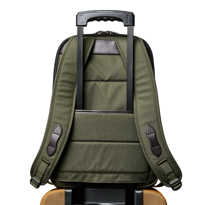 Back view of an olive colored backpack featuring a carrying handle against a white background. 