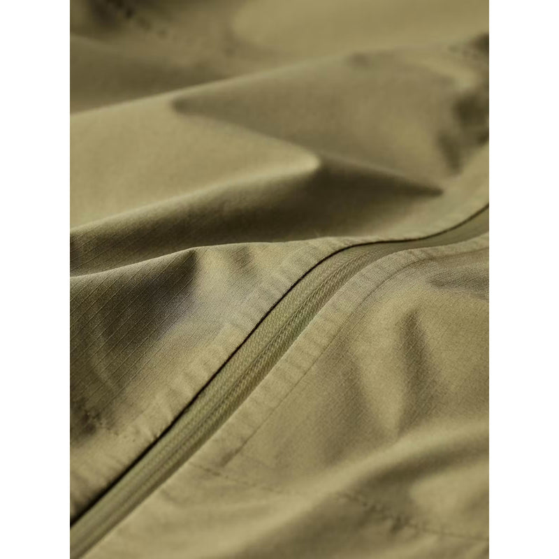 Close-up of olive green fabric with a zipper detail, showing the texture and color of the material.