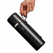 Black thermos held by a hand on a white background