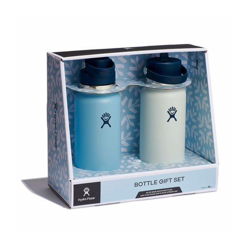 Hydro Flask bottle gift set in retail packaging, featuring two reusable water bottles side by side. The left bottle is matte light blue with a dark navy cap, and the right bottle is matte off-white with a dark navy cap.