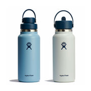 Two Hydro Flask insulated water bottles on a white background, one in light blue and one in off-white, both with dark navy caps and handles.