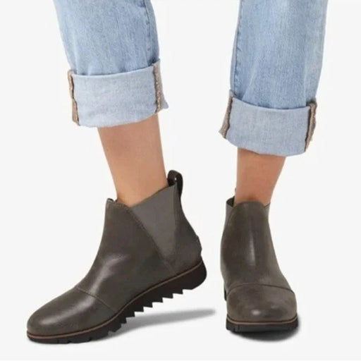 Gray ankle boots worn with rolled-up jeans on a white background
