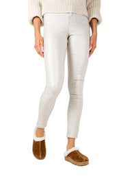 Person wearing light gray leggings and brown slippers on a white background