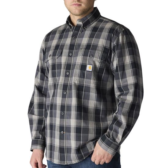 A man wearing a Carhartt long-sleeve plaid button-down shirt in dark gray and beige, paired with blue jeans against a plain white background.