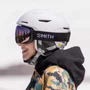 Person wearing a white helmet with Smith logo and goggles on a white background