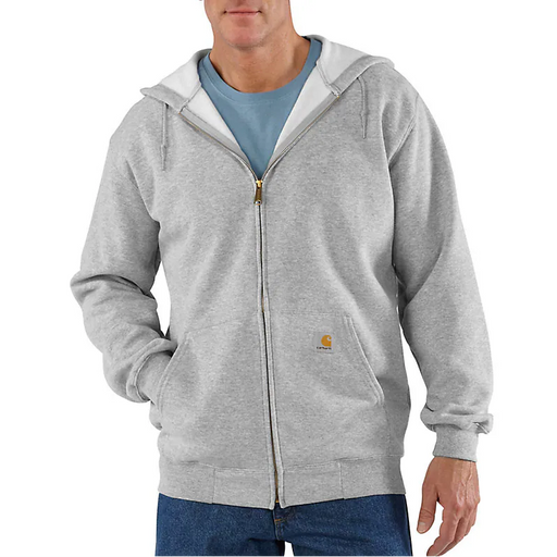 A man wearing a light gray full-zip hoodie with a white hood lining, layered over a blue t-shirt and blue jeans. The Carhartt logo is visible on the chest pocket.