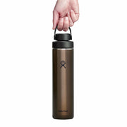 A Hydro Flask insulated water bottle in a dark bronze-brown color, held by a hand to show its carry loop. The bottle has a black lid and features the Hydro Flask logo on the front, set against a plain white background.