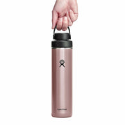 Pink Hydro Flask water bottle with black lid held by a hand on a white background