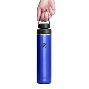 Blue Hydro Flask water bottle with black lid held by a hand on a white background