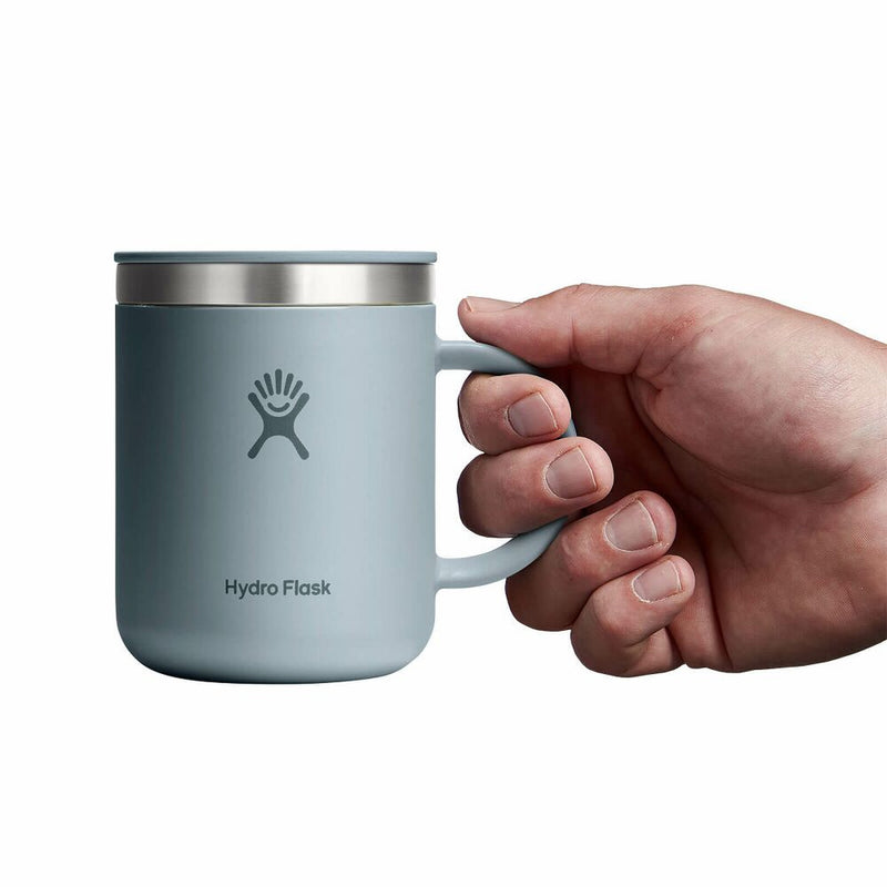 Hand holding a Hydro Flask mug on a white background
