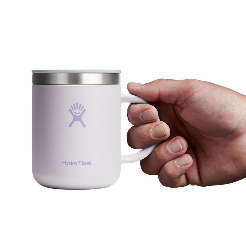 Hand holding a lavender Hydro Flask mug on a white background
