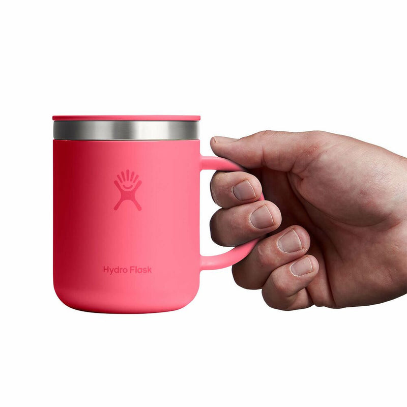 Pink Hydro Flask mug held by a hand on a white background